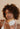 Woman with curly hair holding the Mimane Glow Hydrate and Strengthen Hair Mask