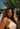 Woman with long defined curls holding Mimane Glow hair oil
