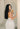 Woman in profile with long dark hair holding Mimane Glow hair oil