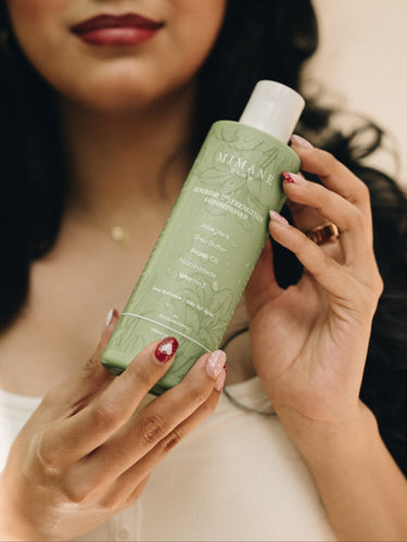 Mimane Glow Nourish and Strengthen Conditioner held by model — moisturizing conditioner for all hair types