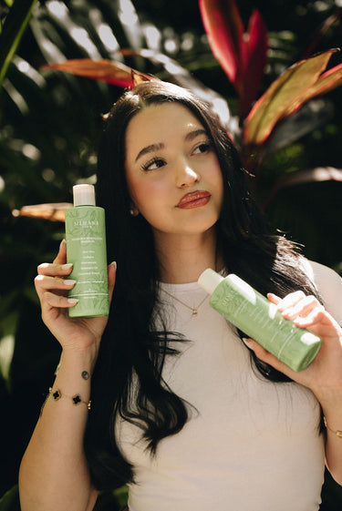 Model holding Mimane Glow Nourish and Strengthen Shampoo and Conditioner — natural hair care duo