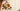 Argan nuts and a glass of golden oil on linen