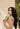 Woman with long dark wavy hair holding Mimane Glow Nourish and Strengthen Conditioner