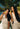 Two women with long dark hair holding Mimane Glow hair oil under palm trees
