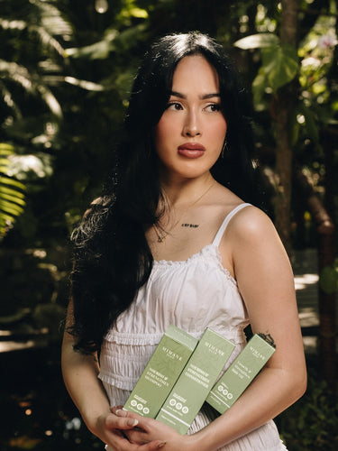 Xilenia Mena founder of Mimane Glow holding the full Glow Kit — Growth and Strengthen Hair Oil, Shampoo, and Conditioner